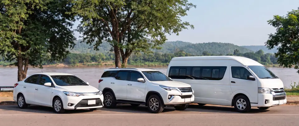 รถเก๋ง SUV และรถตู้สีขาว ติดป้าย TAXI บนหลังคา จอดริมแม่น้ำโขงที่โขงเจียม
